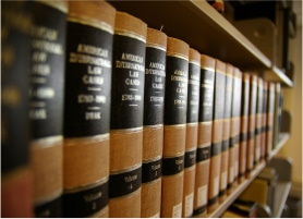 A row of leather-bound law books on a shelf, with gold lettering on black spines, showcasing titles from the American law collection.